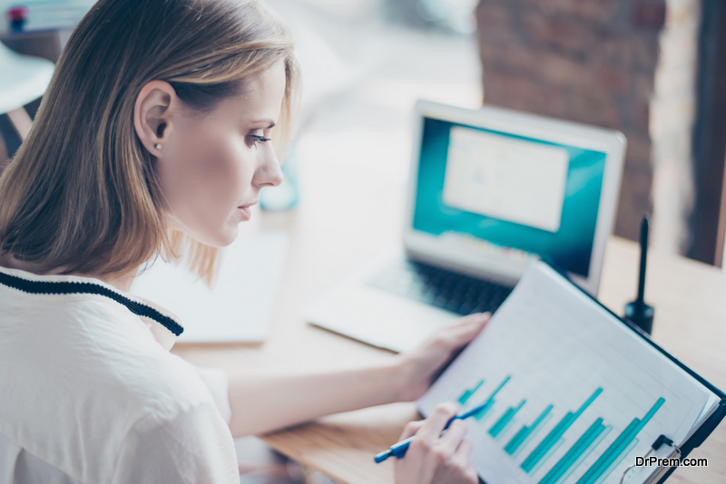 Close up portrait of beautiful pondering clever businesswoman looking at top results on her investments