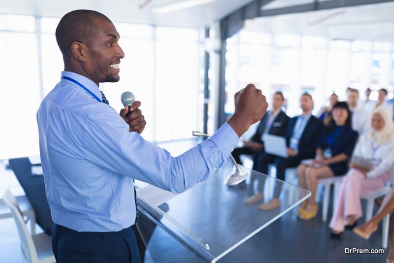 Side view of caucasian Male speaker speaks in business seminar at conference