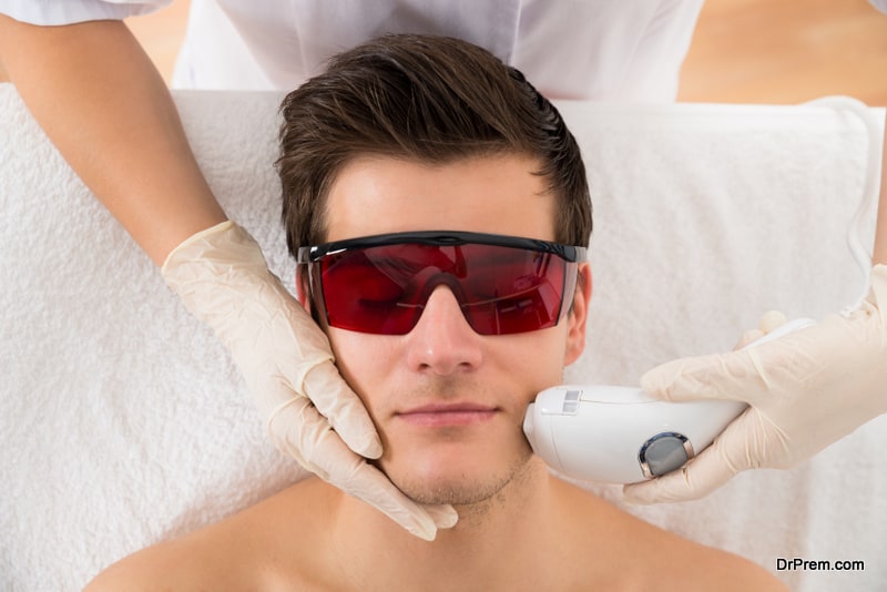 Close-up Of Beautician Giving Laser Epilation Treatment To Young Man Face