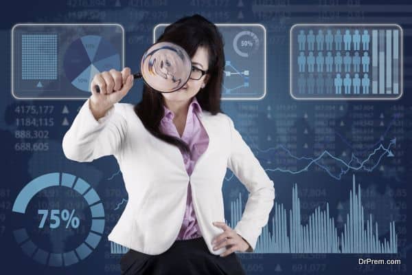 Female entrepreneur using a magnifier to monitoring her business in front of financial background