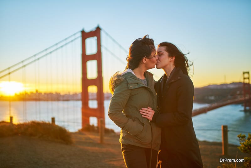 Romantic lesbian couple kissing at golden gate bridge