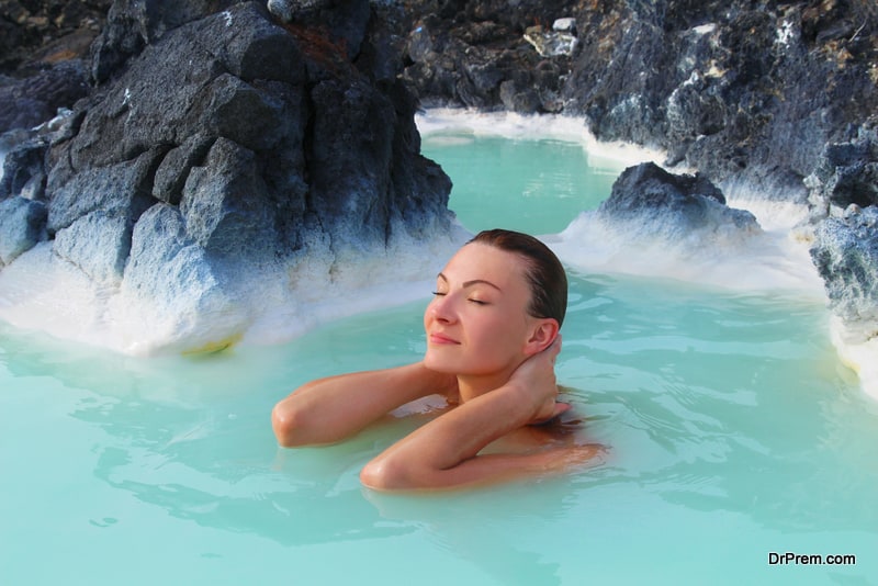 Woman enjoys spa in hot spring Blue Lagoon in Iceland