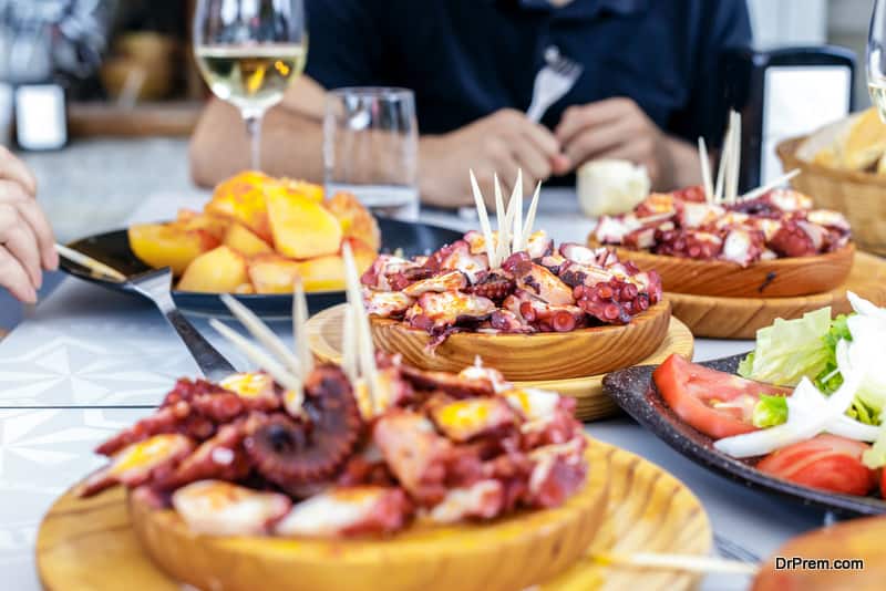 People eating Pulpo a la Gallega with potatoes. Galician octopus dishes. Famous dishes from Galicia, Spain