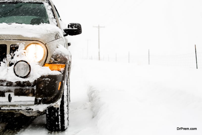 vehicle lights are on during daytime in a snowy day