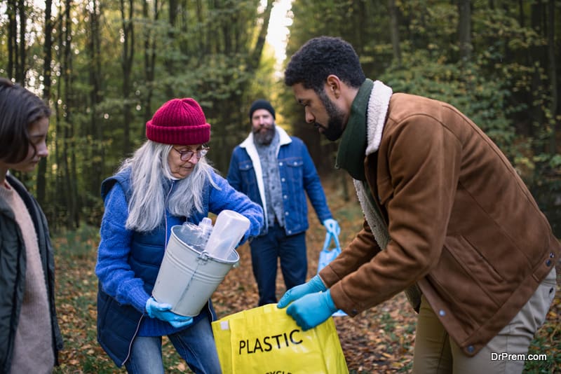 A diverse group of volunteers cleaning up forest from waste