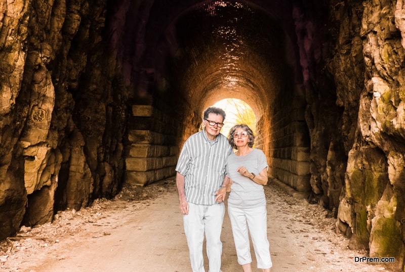 Full-body-portrait-of-senior-couple-standing-in-former-tunnel-converted-into-recreational-trail-in-Missouri