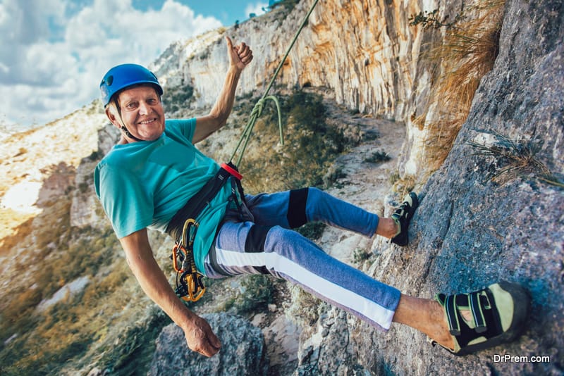 Senior man with a rope climbing on the rock