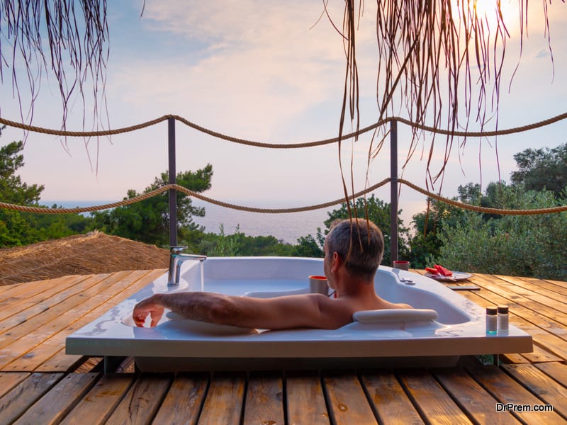  male lies chilled in a hot tub at a luxurious exotic spa resort hotel