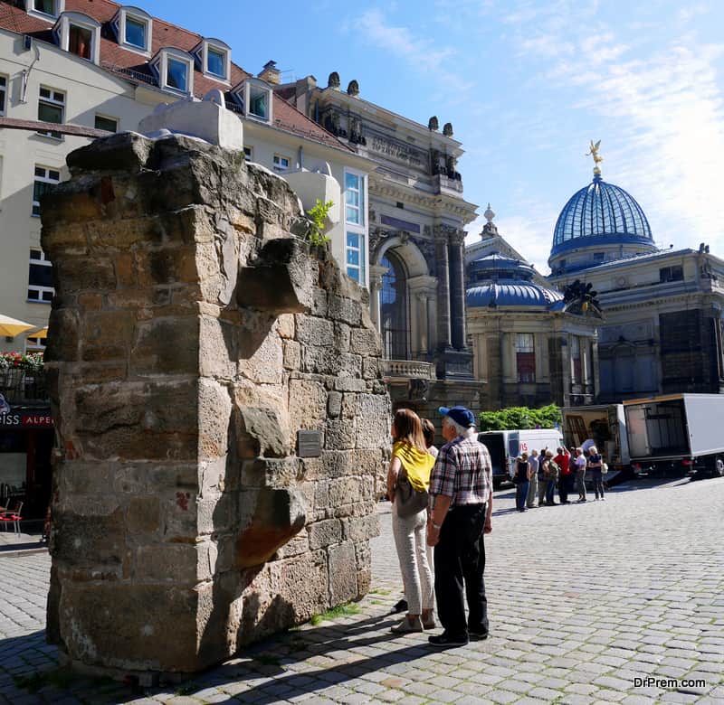 reading-inscription-on-remains-of-Frauenkirche-church-found-among-the-rubble-during-the-reconstruction-and-stands-nowadays-next-to-the-church-in-memory-of-the-aerial-bombardments-on-Dresden