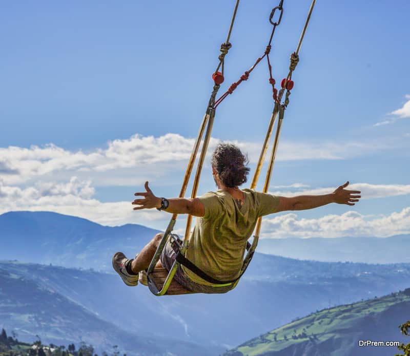 Person rides swing over an abyss