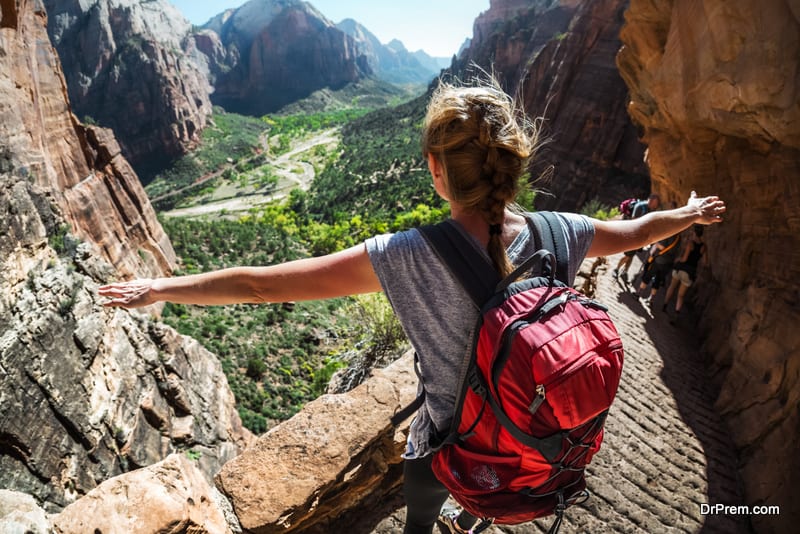 Woman hiker standing with raised hands