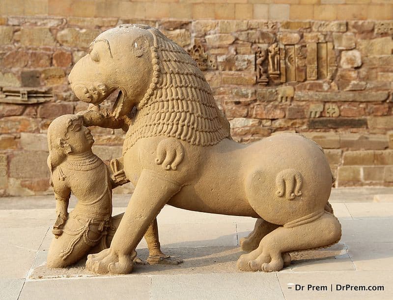 A Warrier fighting with a lion bare handed at the entrance of the temple.