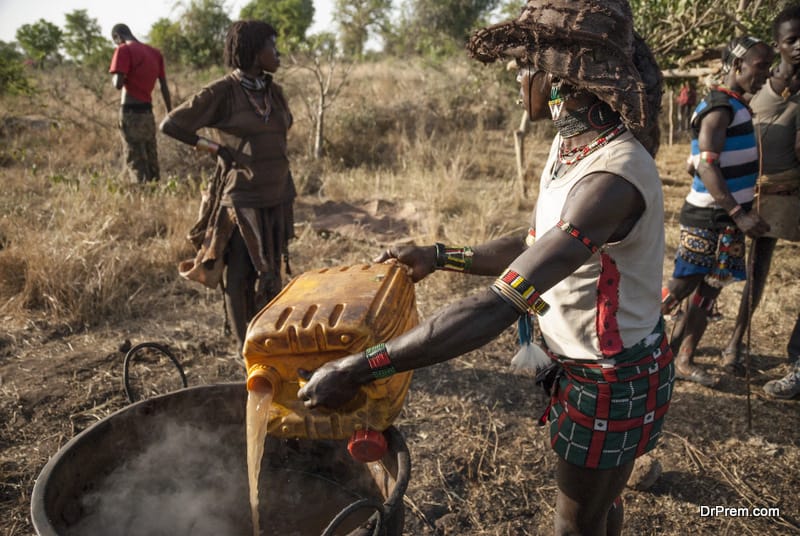 Hamer man prepares sorghum beer in Dimeka, Valley Omo, Ethiopia.