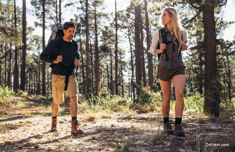  Hiker couple exploring nature walking through the woods