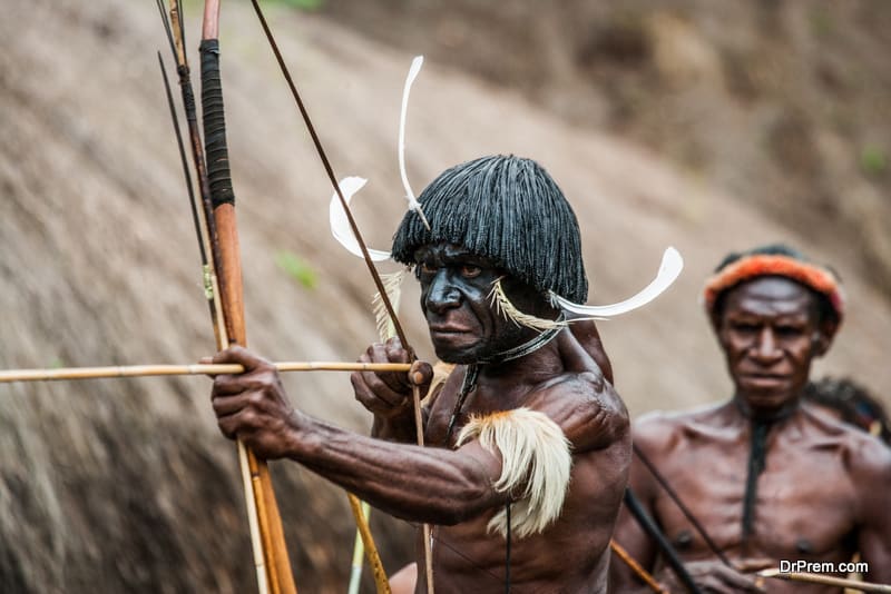 Men Dani tribe shoot an arrow