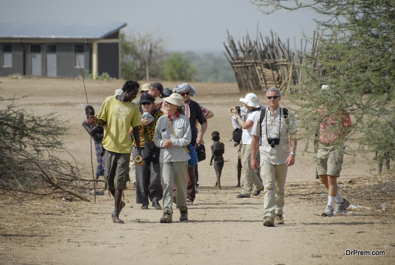 Western tourists are welcomed by Karo people in Kolcho, Ethiopia.