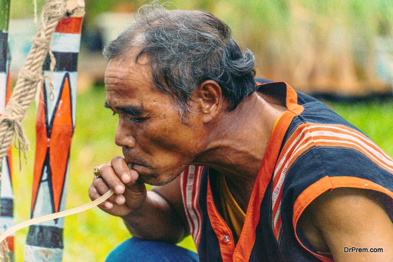 man drinking Ruou Can (vietnamese fermented rice wine in earthenware jars)