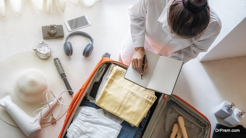 Happiness young woman packing a clothes and stuff