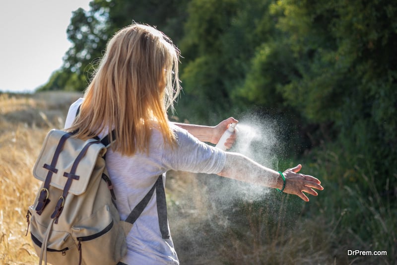 Woman tourist applying mosquito repellent on hand