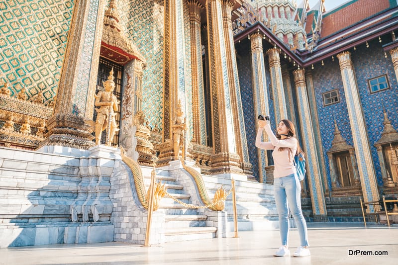 Woman travel with camera sightseeing in temple