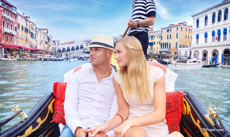 Young happy couple swimming on the gondola on Grand Canal in Venice