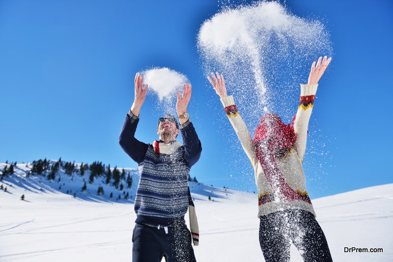 Carefree happy young couple having fun together in snow