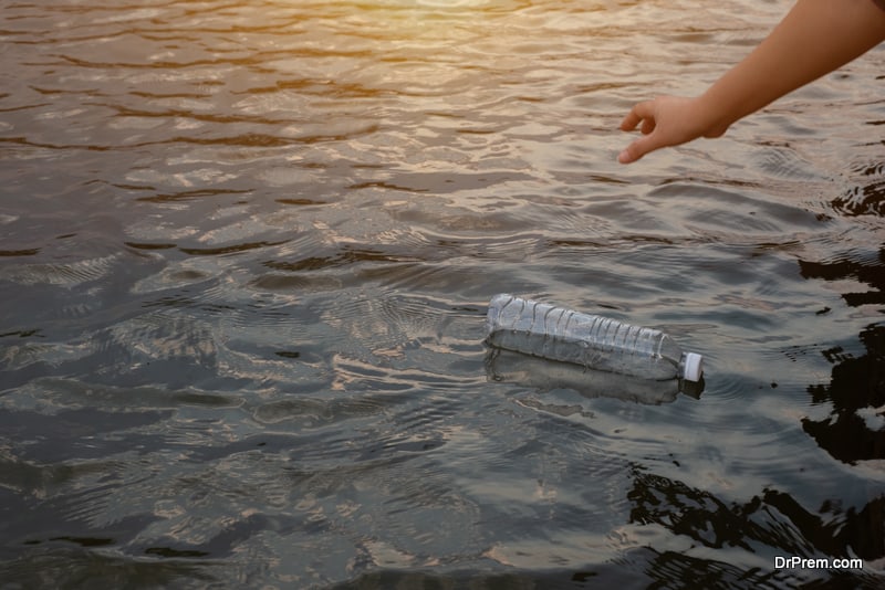 Woman hand to pick up the used waste plastic bottle