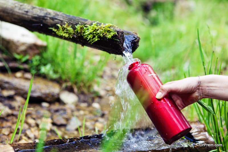 refilling the water canteen at a forest spring