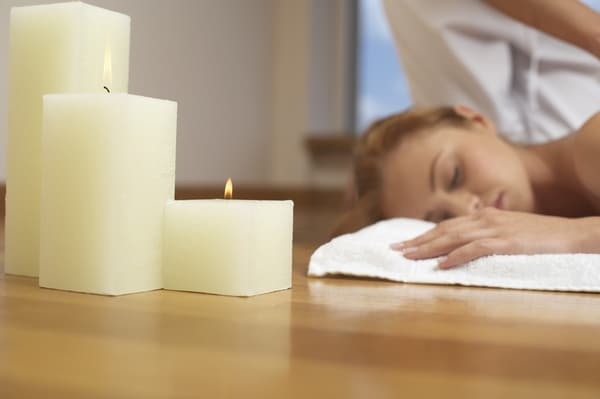Woman getting massage with aromatherapy candles beside her