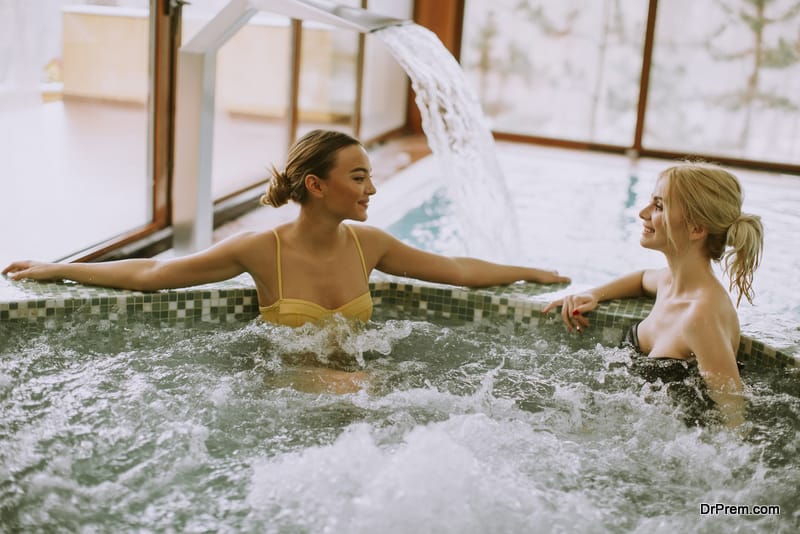 Pretty young women relaxing in the whirlpool bathtub at the poolside