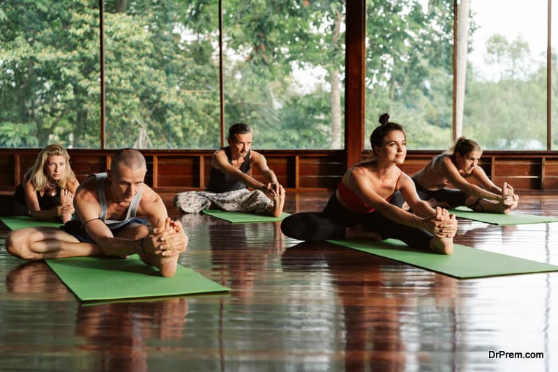 A group of people attending a yoga class in a tropical environment of a yoga meditation retreat