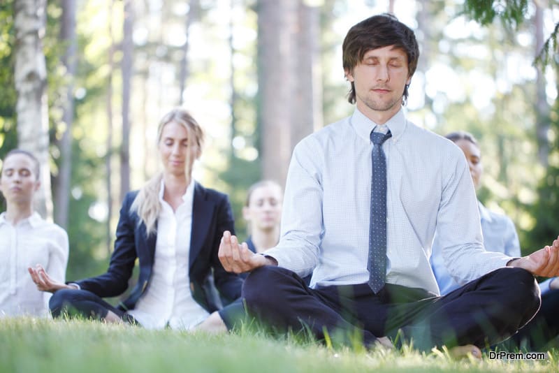 Business people team practicing yoga in park