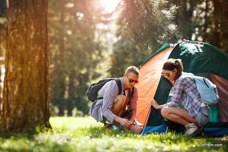 Campers setting up the tent at the forest.