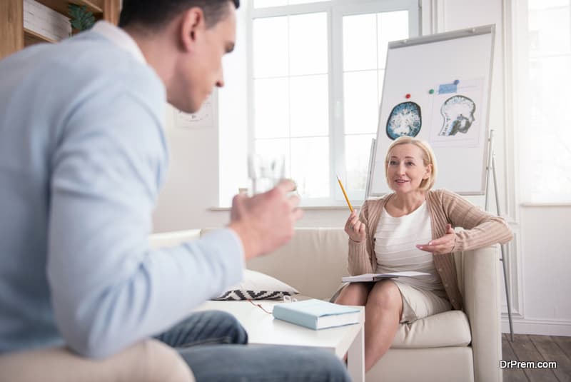 Professional opinion. Successful mature psychologist using notebook while helping man