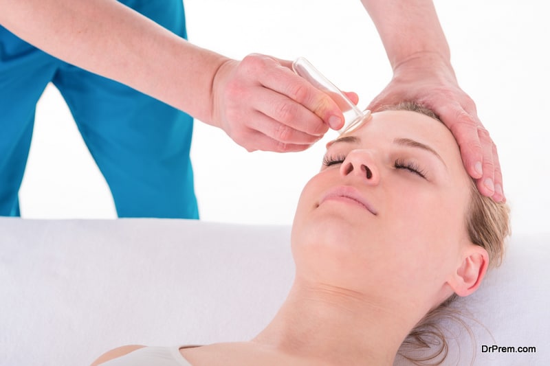 Young Woman receives facial cupping massage facial rejuvenation treatment at acupuncture wellness spa