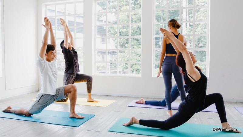 sporty attractive people practicing yoga lesson with instructor