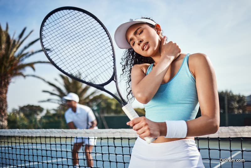 Shot of an attractive young woman suffering from a neck injury during tennis practice with her teammate