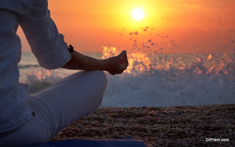 Woman Practicing Yoga near the Ocean at Sunset