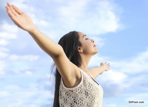 Portrait of arab woman breathing fresh air with raised arms