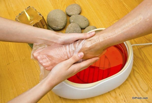 woman foot in paraffin bath at the spa