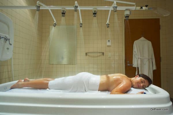 Woman enjoying hydrotherapy in vichy shower