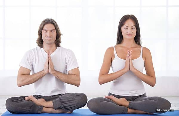 Young couple in lotus pose