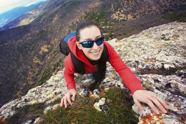 woman climber is climbing on a rock