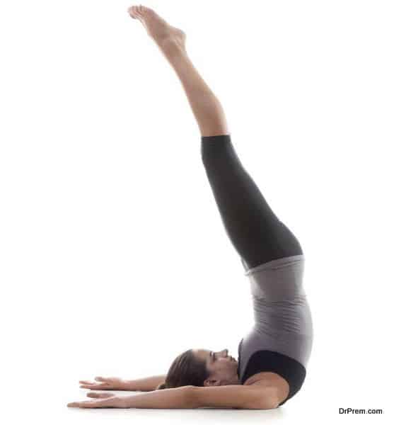 Sporty yoga girl on white background exercising standing on shoulders