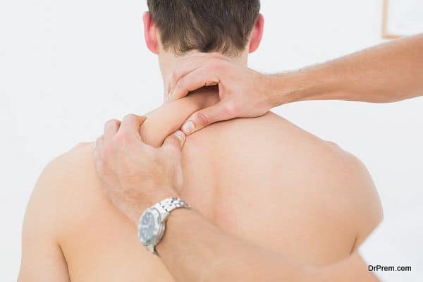 Rear view of a man being massaged by a physiotherapist