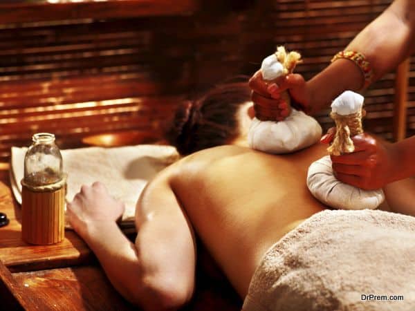 Woman having Ayurveda massage with herbal ball.