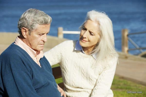 Senior Woman Comforting Depressed Husband Sitting On Bench