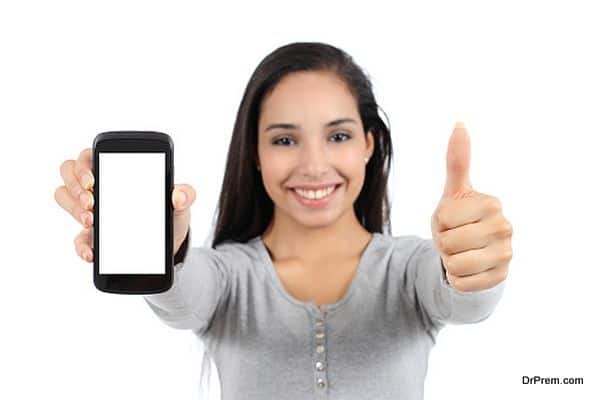 Woman showing a smart phone screen and thumb up isolated