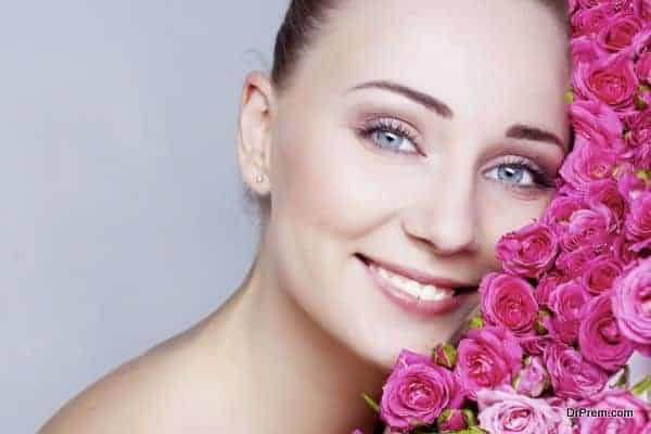 Beautiful girl face near the rose flowers