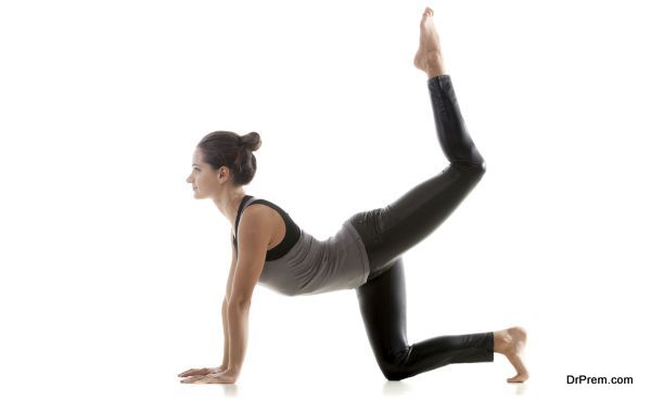 Sporty yoga girl on white background doing exercises for buttocks